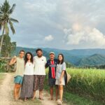 Martina e Lorenzo del progetto Giro.vagamondi, assieme ad alcuni amici conosciuti durante un Workaway autentico e sostenibile in Thailandia, davanti a campi di riso