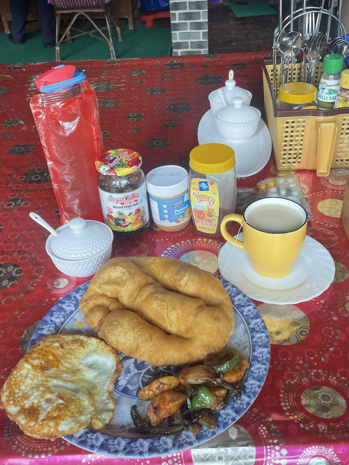 Set breakfast con gurung bread composto da: uova fritte, verdure e patate, milk tea, marmellata e pane fritto tibetano